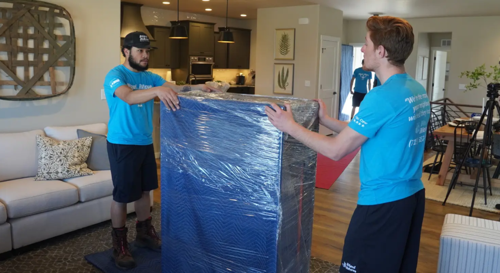 Squadra di sgombero appartamento che trasporta materasso imbustato in casa moderna - Sgombero cantine e appartamenti Milano